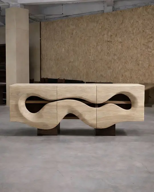 A pale timber sideboard with wave-shaped carved cut-outs across the doors, raised on a dark plinth base